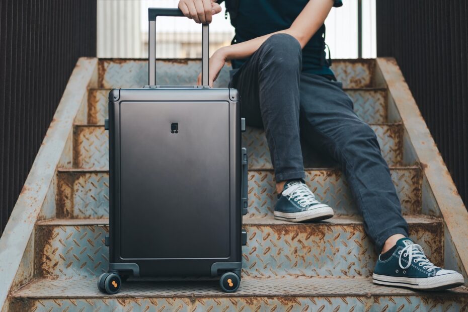 a person sitting on a set of stairs with a suitcase